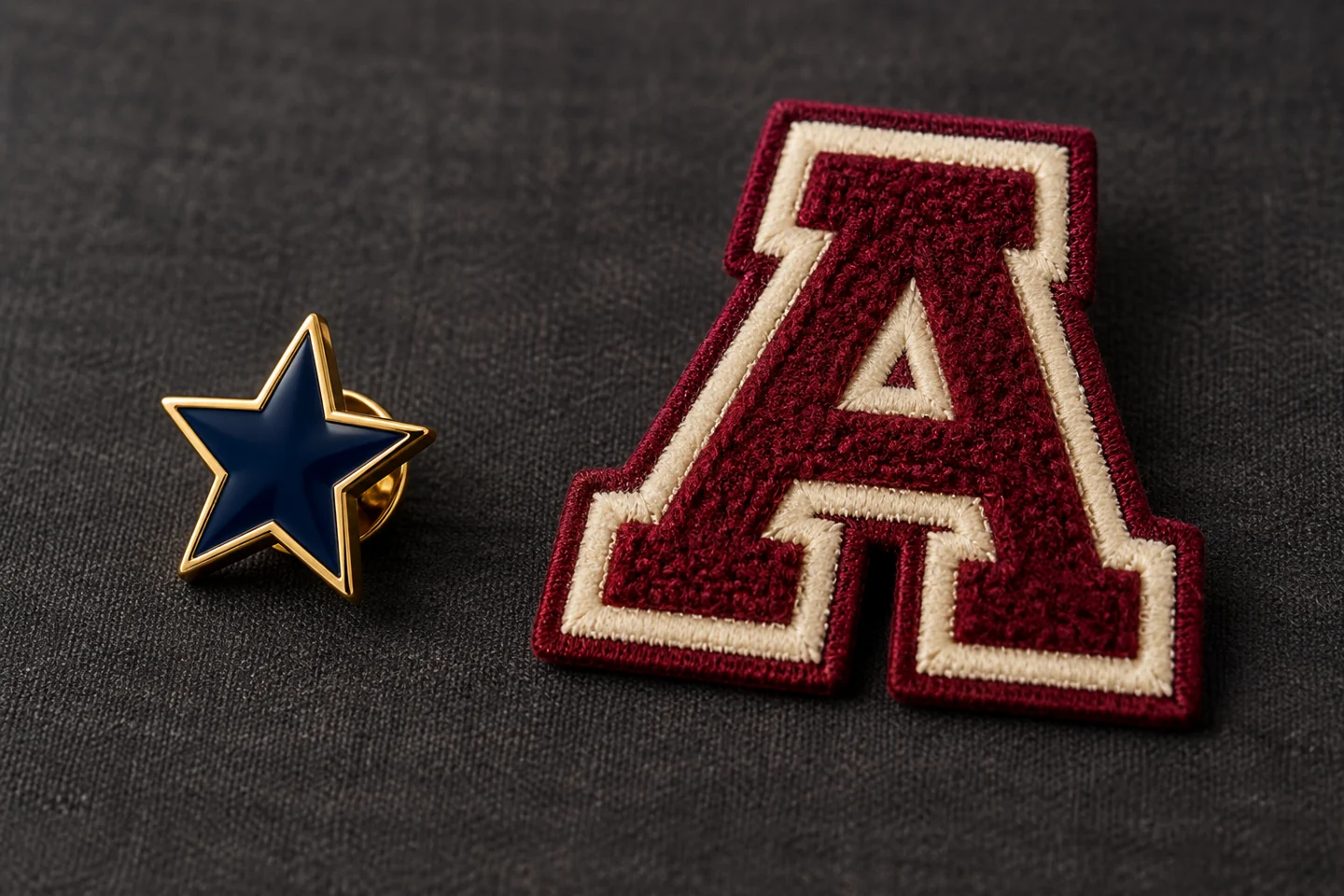 Illustrative enamel star lapel pin and chenille letter patch